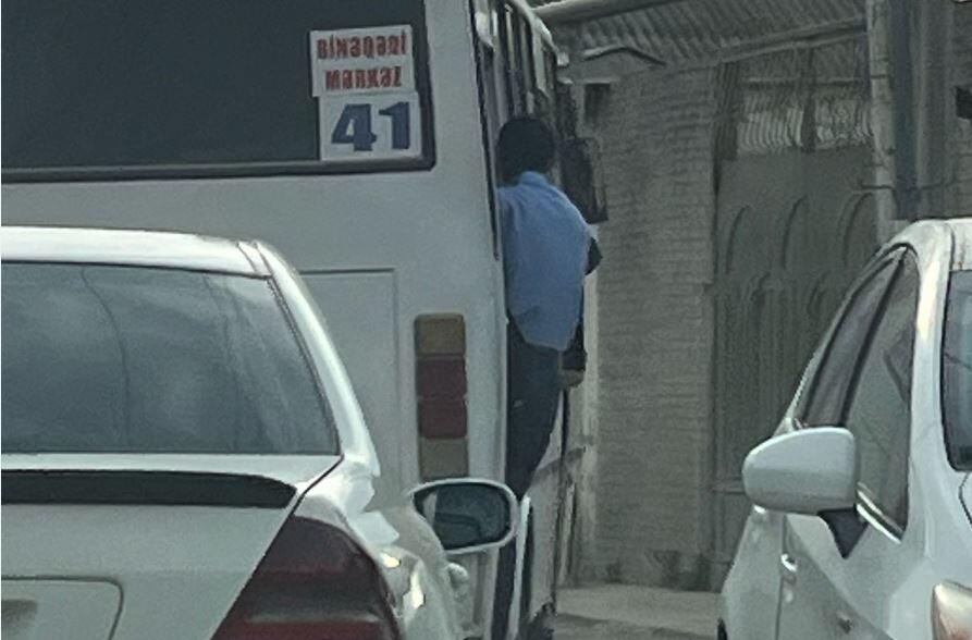 Bakıda sərnişinlər avtobusun qapısından sallanıb gedirlər 